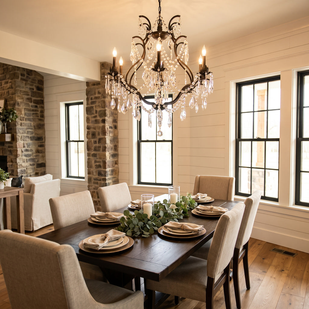 Black wrought iron and crystal chandelier above a modern farmhouse dining table
