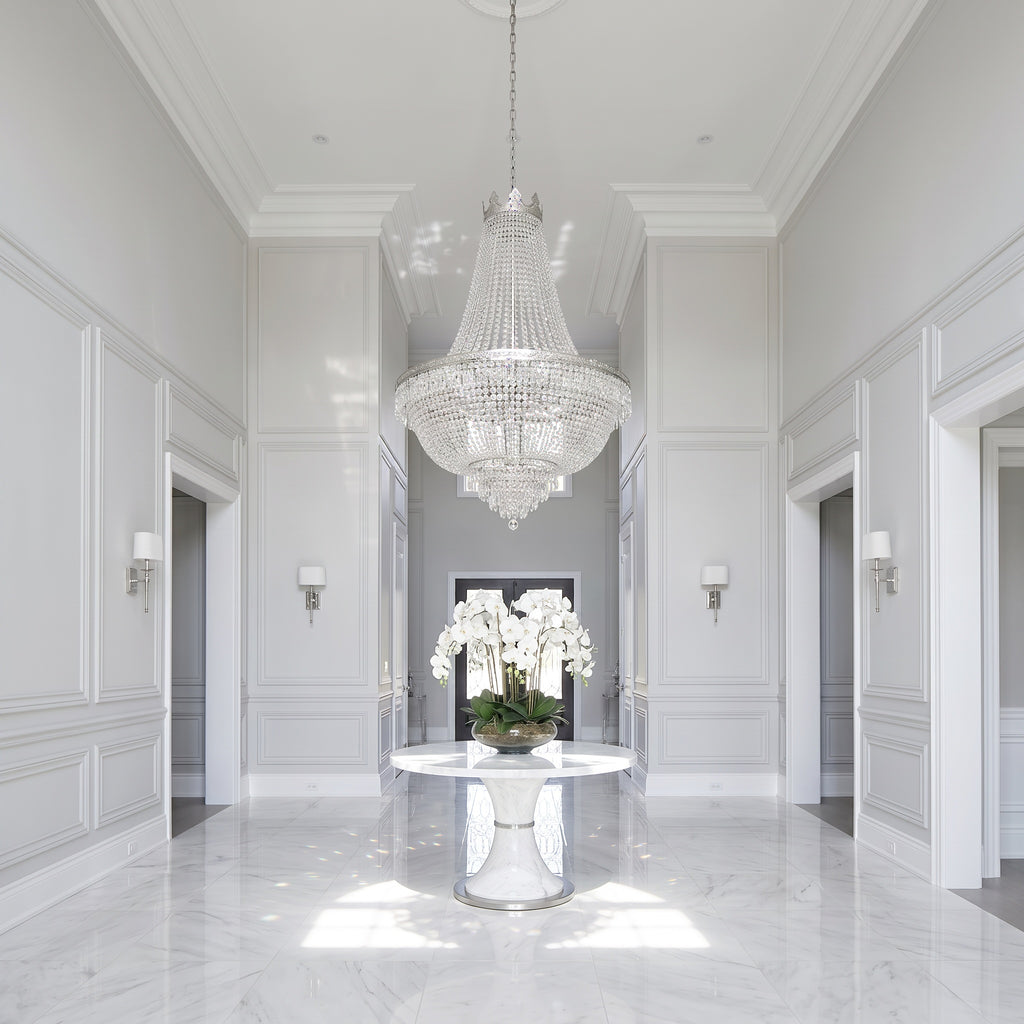 French Empire silver crystal chandelier in a bright white marble luxury foyer